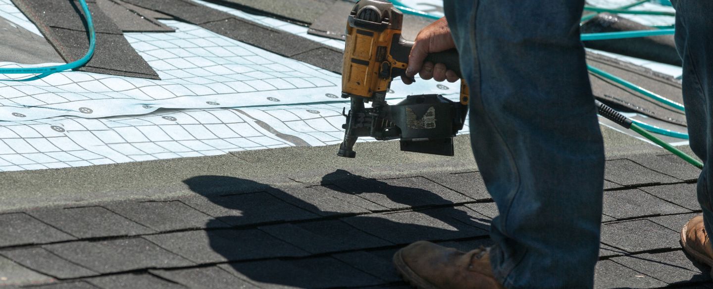 roofer replacing old roof shingles with new shingles on residential home coos bay or